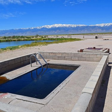 Fish lake valley hot spring. Geothermal exploration well to the right, under some artesian head as there is no pump, emptying into the pool then a collection pond. Nevada’s highest point, boundary peak, in the background. #hotsprings #fishlakevalleyhotsprings #fishlakevalley #esmeraldacountynv #nevada #travelnevada #whitemountains #boundarypeak #boundarypeaknevada