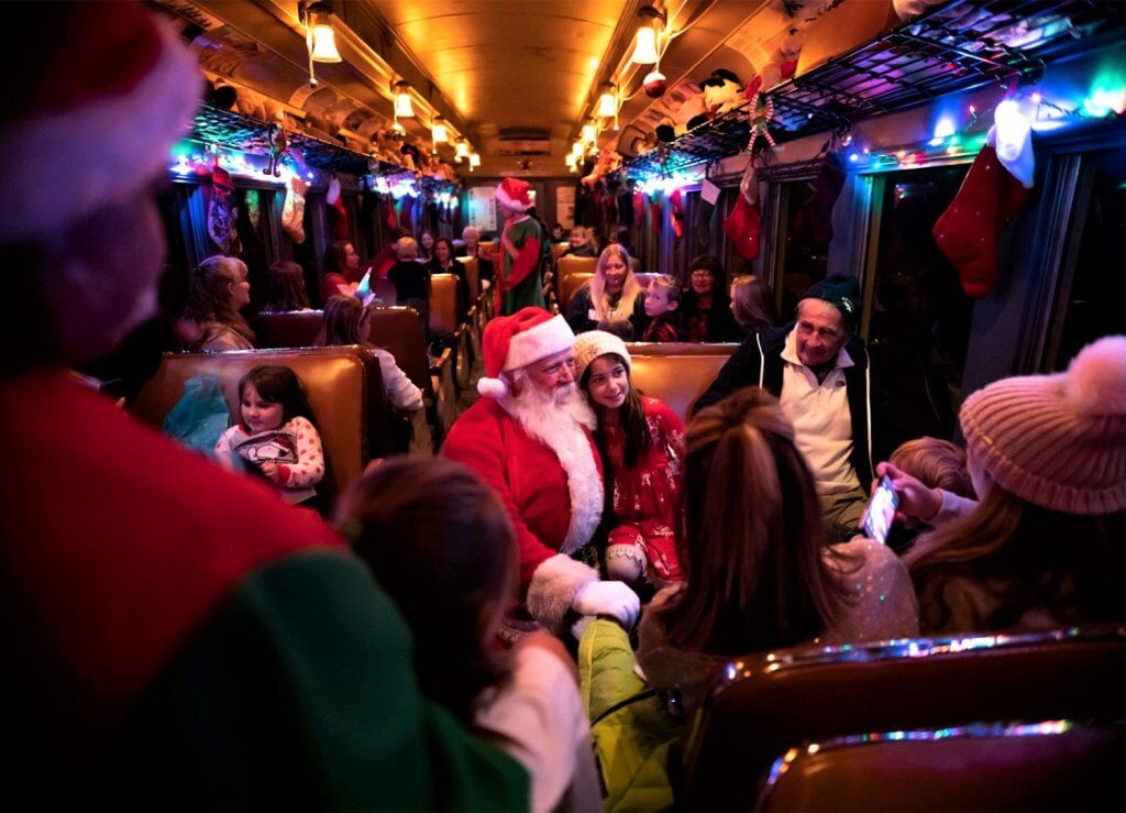 santa sitting with guests on the polar express