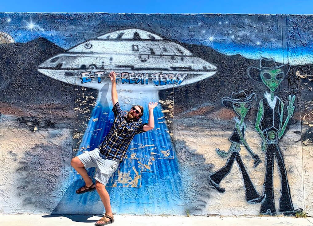 man in front of mural at extraterrestrial highway experience