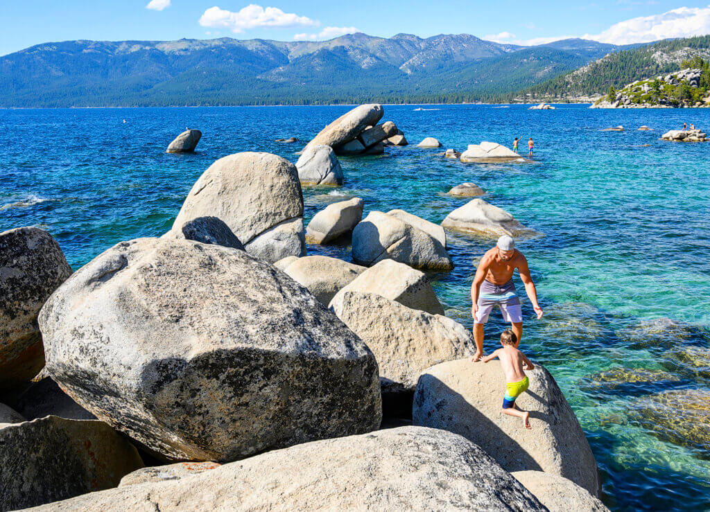 father and son rock hopping at sand harbor in north lake tahoe